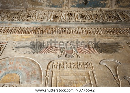 Egyptian hieroglyphic carvings and paintings on wall of the ancient temple at Medinat Habu in Luxor