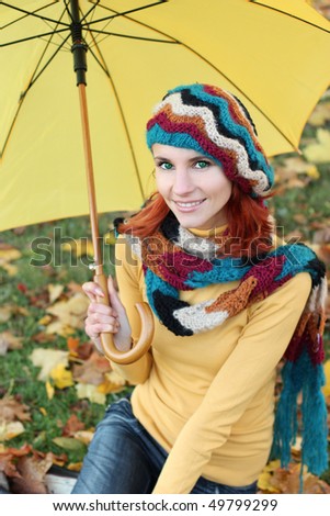The beautiful young woman on walk in autumn park