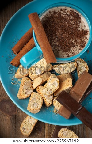 Mug of coffee latte and confectionery on rustic wooden background. Top view point. Focus on cookies.