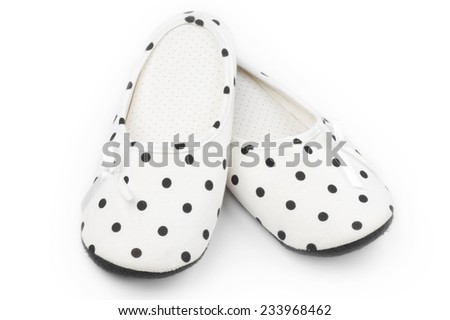 Pair of feminine slippers with white and black polka dot decor isolated on white background.