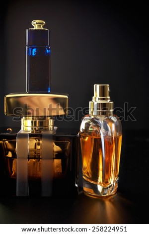 Various bottles of woman perfume on dark background.
