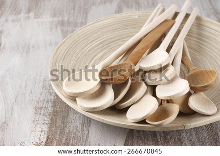 Assorted wood spoons in wooden dish on rustic background.