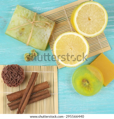 Various natural soaps, lemon and cinnamon on aquamarine wooden background. Top view point.
