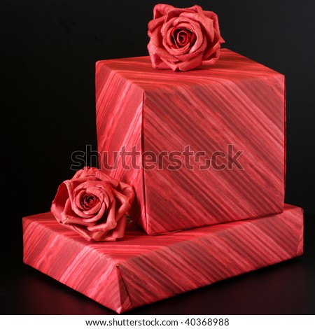 Two striped red gifts with red roses on black background.