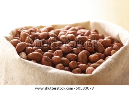 Heap of raw peanuts in canvas bag.