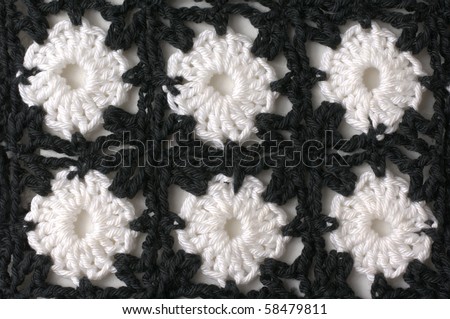 Crocheted fabric with black and white pattern of cotton yarn.