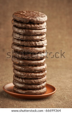 Stack of chocolate cookies on brown canvas.