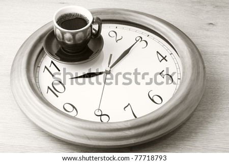 Coffee time: cup of coffee on clock dial. Sepia.
