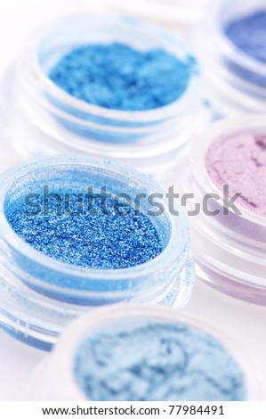 Set of powder eye shadows in jars close-up.
