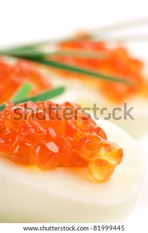 Close-up of canapes with egg, salmon caviar and onion.