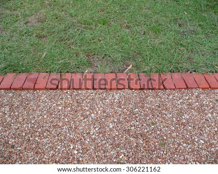 Brick edging between pebbles and grass