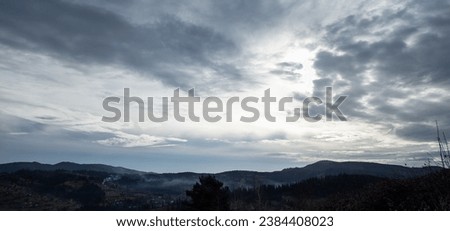 Foto Bild Blick über ein graues Zweckgebäude hinweg auf ein Bürogebäude mit Fenstern in Teilansicht vor blauem Himmel mit einer einzelnen Wolke