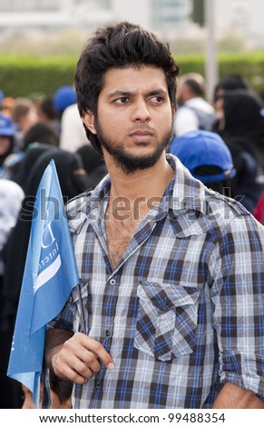 DUBAI - UAE - APRIL 06 2012: Unidentified person holding peace march flag during the \