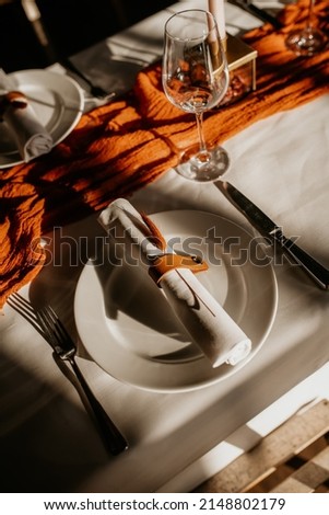 Table setting for an event or wedding boho chique. Luxury and elegant in orange with plates and wineglasses Foto stock © 