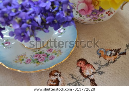Cross stitch birds with violets and teacup