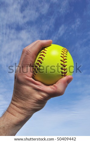 Player Gripping a Yellow Softball Against a Blue Sky