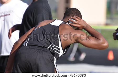 SPRING LAKE PARK, MN - MAY 3: Unidentified teen boy prepares to toss the shot put at a High School Track and Field Meet on May 3, 2011 in Spring Lake Park, Minnesota.