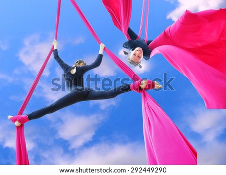 Outdoor activity of cheerful child training on aerial silks or ribbons in the sky.  Childhood, sports, active lifestyle concept.