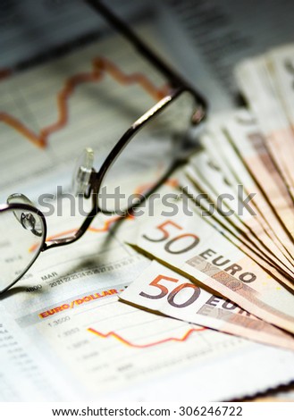 Financial paper with business page and glasses
