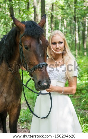Beautiful bride and a horse in the forest