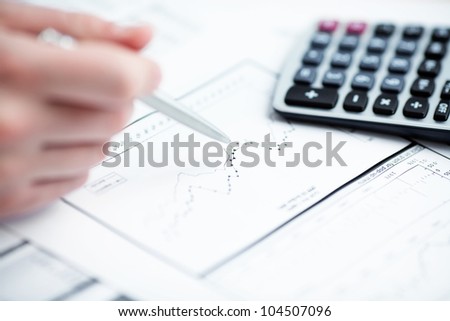 Financial data analyzing. Counting on calculator. Close-up. Selective focus