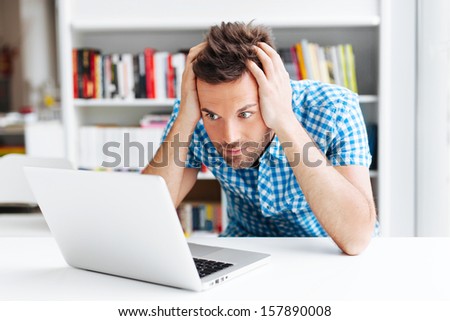 Worried man looking on laptop
