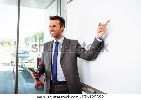 Young professional pointing at a whiteboard