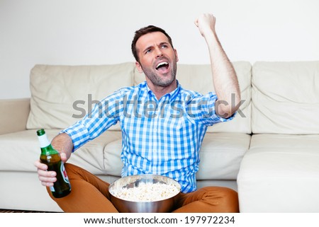 Excited sports fan watching a game on tv