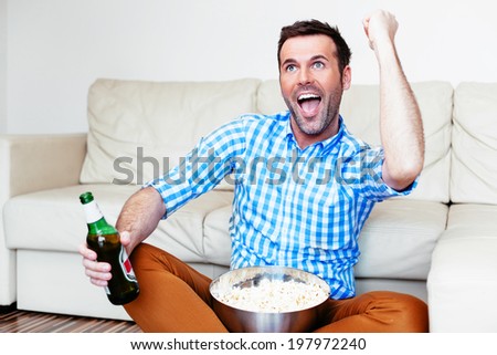 Joyful man enjoying the victory moment of his team on tv