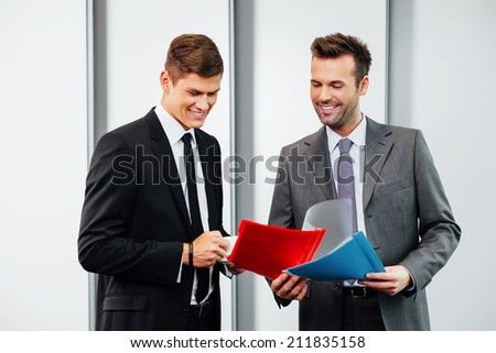 Two professionals talking and looking at files