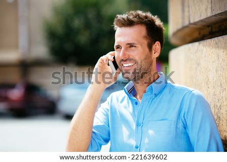 Young attractive man talking on his mobile in the street