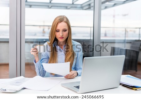 Young female business owner busy working at desk in office