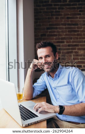Happy man sitting with computer at office