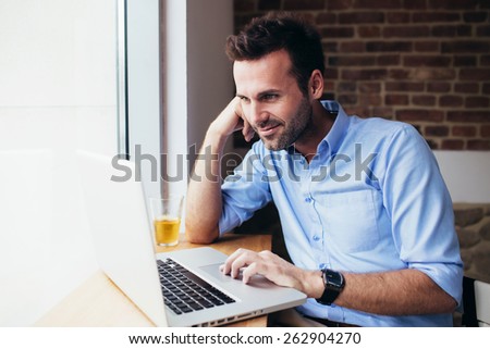 Handsome man working on laptop at office