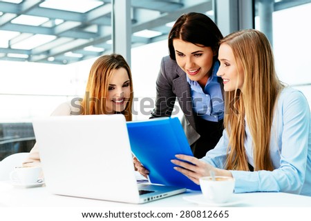 Three businesswomen at office working with laptop