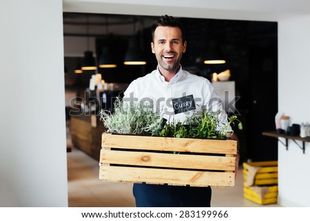 Successful restaurant manager holding box with fresh spices