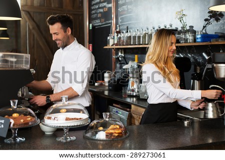 People working at cafe, behind the bar