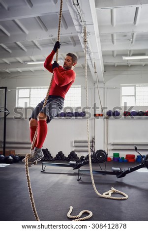 Fitness rope climb exercise at gym