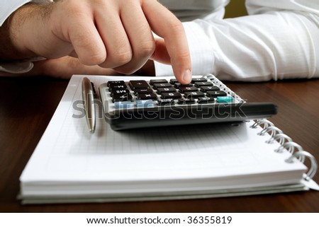 Financial data analyzing. Counting business data on the table closeup