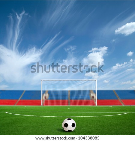 Green football ground against the sky