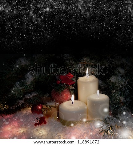 Christmas gift boxes with burn candles under decorated fir on snow