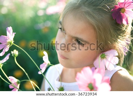 The sad girl and wild flowers. Small depth of focus