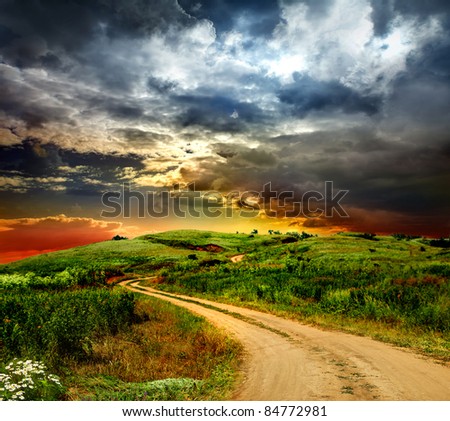 beautiful view of the sunset in a field on a rural road