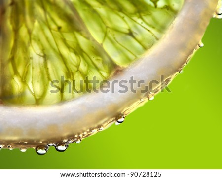 Drops of juice falling of the succulent lemon. A strong light behind the lemon gives the dark aspect.