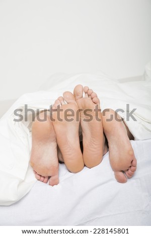 Married couples feet in bed