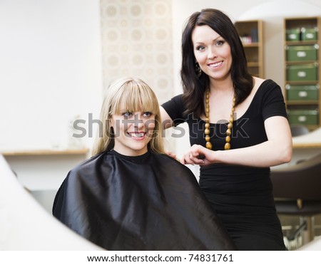 Hairdresser in action with blond customer