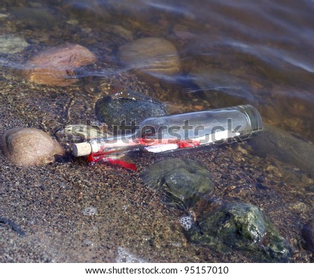 Message in a bottle at the edge of the water