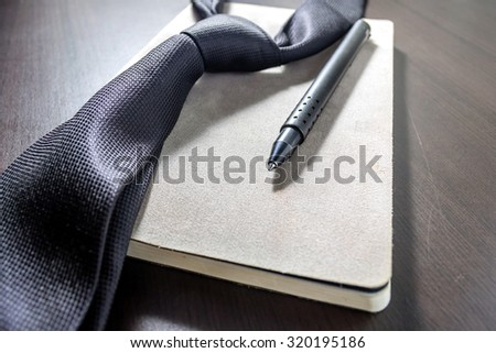 tie and notebook on desk / selective focus / filter vintage.