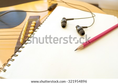 Acoustic Guitar with blank notebook for music.