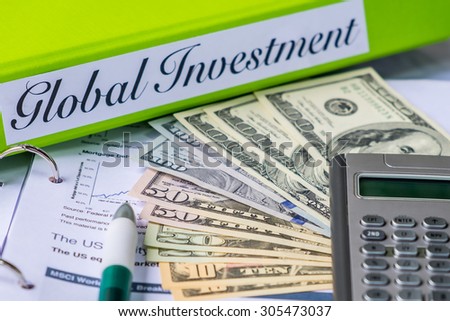 Folders with the label of Global investment , dollar bank notes and pen.